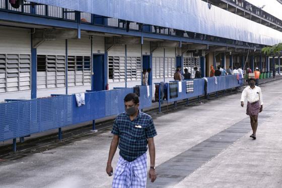 Trabajadores migrantes con máscaras protectoras salen de sus alojamientos en Singapur, el 8 de abril de 2020, durante la pandemia del coronavirus