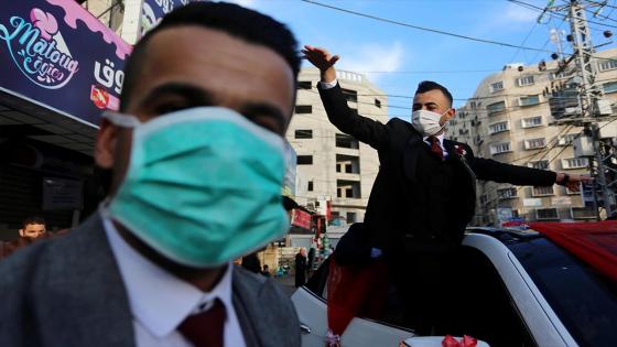 Una pareja de novios y sus invitados a la boda utilizan mascarillas médicas como medida de precaución contra el coronavirus (COVID-19), ocurrida durante la pandemia en Ciudad de Gaza.  Foto:  Ashraf Amra/ Anadolu