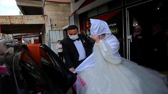 Una pareja de novios y sus invitados a la boda utilizan mascarillas médicas como medida de precaución contra el coronavirus (COVID-19), ocurrida durante la pandemia en Ciudad de Gaza.  Foto:  Ashraf Amra/ Anadolu